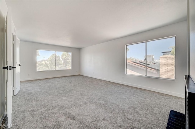 unfurnished living room featuring carpet floors and baseboards