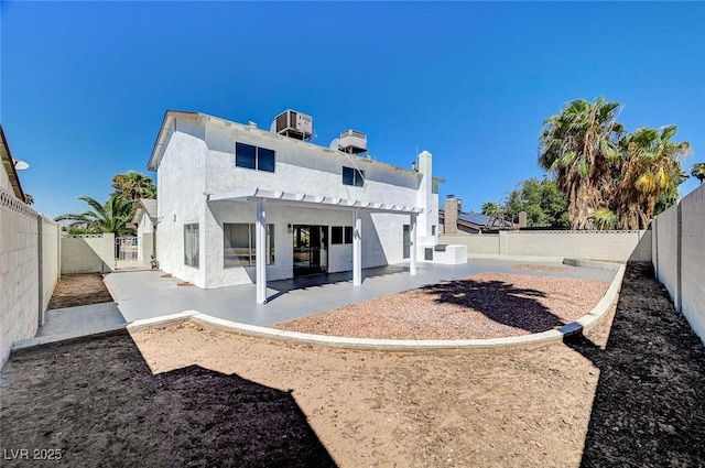 rear view of house featuring a patio area, a fenced backyard, and stucco siding