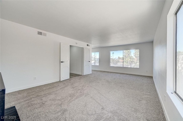 empty room featuring baseboards, visible vents, and carpet flooring