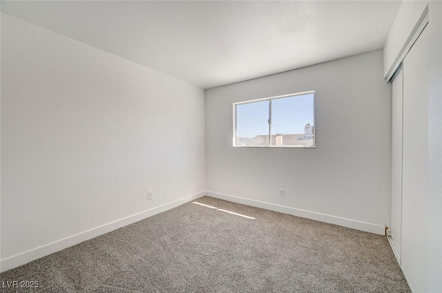 unfurnished bedroom featuring carpet, baseboards, and a closet