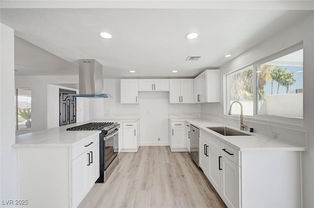 kitchen featuring island range hood, a sink, visible vents, stainless steel dishwasher, and range with gas cooktop