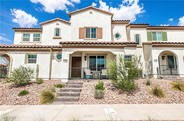 mediterranean / spanish-style home featuring a porch and stucco siding