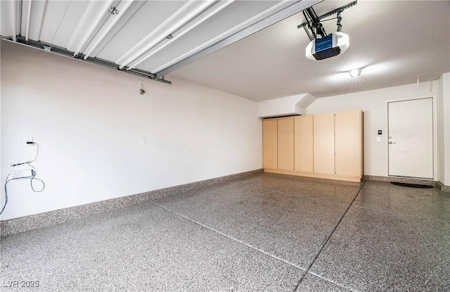 garage with baseboards and a garage door opener