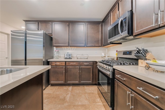 kitchen with stainless steel appliances, light countertops, and dark brown cabinets