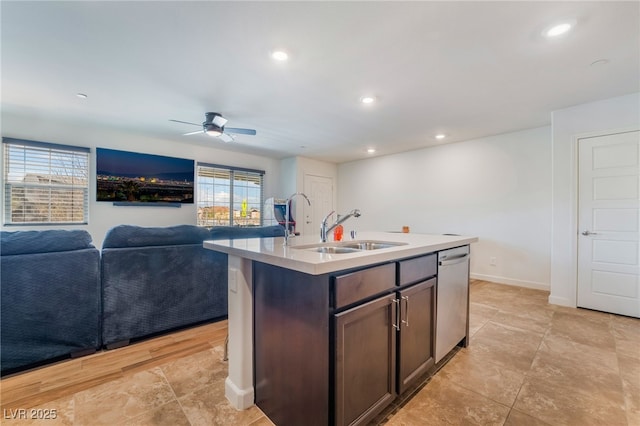 kitchen featuring a center island with sink, recessed lighting, light countertops, stainless steel dishwasher, and a sink