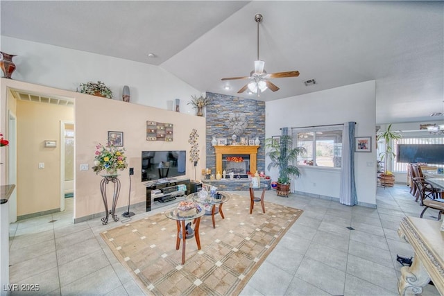 living area featuring light tile patterned floors, visible vents, a stone fireplace, and vaulted ceiling