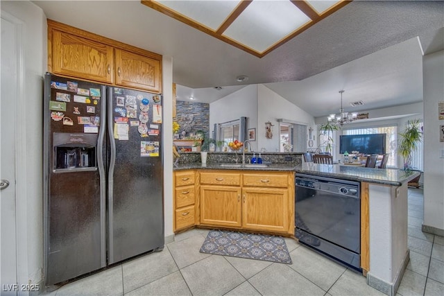 kitchen featuring a chandelier, dishwasher, a peninsula, stainless steel fridge, and a sink