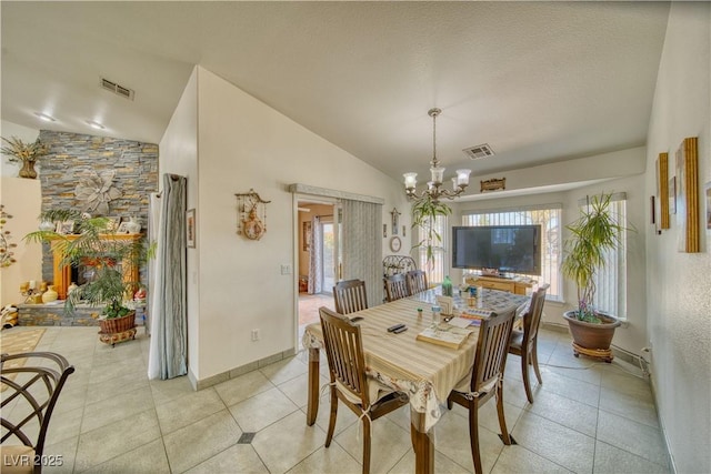 dining area featuring an inviting chandelier, lofted ceiling, light tile patterned flooring, and visible vents