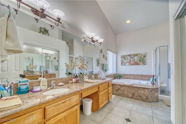 full bath with tile patterned flooring, a garden tub, double vanity, a stall shower, and a sink