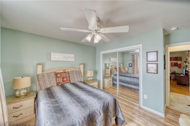 bedroom with a closet, baseboards, a ceiling fan, and wood finished floors