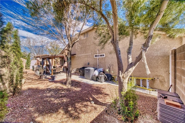 view of side of home featuring a patio area, central AC unit, and stucco siding