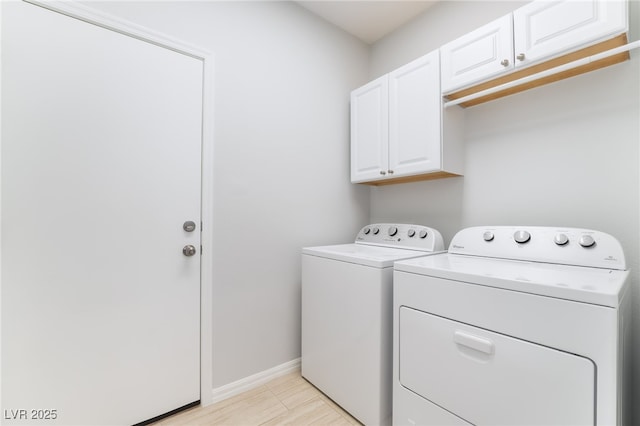 clothes washing area featuring cabinet space, washer and clothes dryer, and baseboards