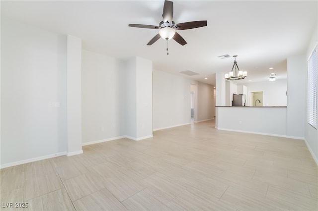 unfurnished living room with ceiling fan with notable chandelier, a sink, visible vents, and baseboards