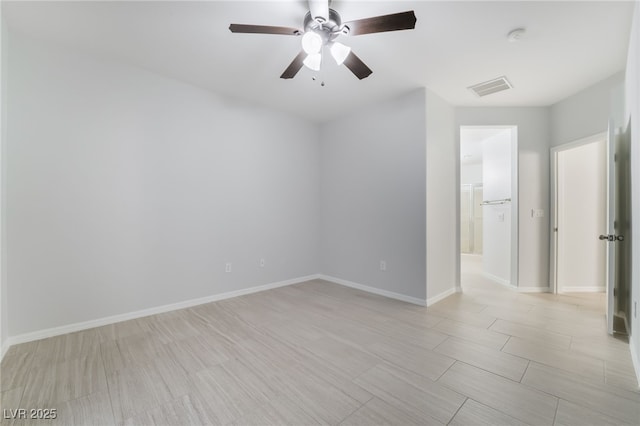 unfurnished room with baseboards, visible vents, and a ceiling fan