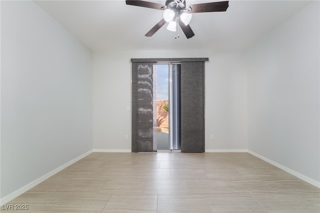 spare room featuring baseboards and a ceiling fan