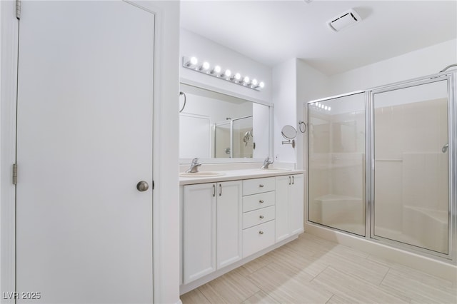 bathroom featuring a sink, visible vents, and a shower stall