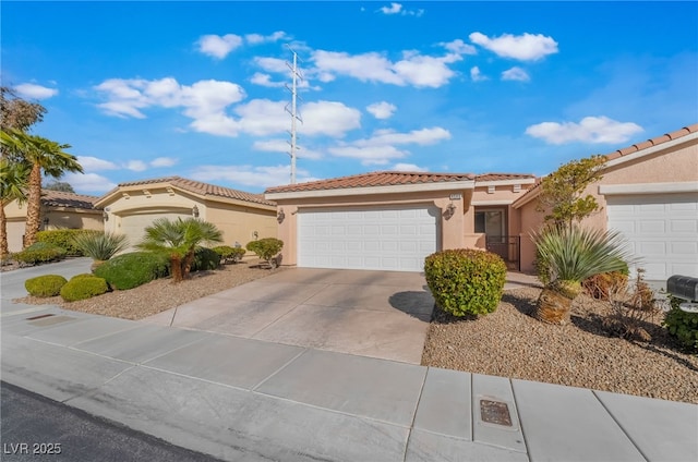 mediterranean / spanish house featuring driveway, an attached garage, a tiled roof, and stucco siding