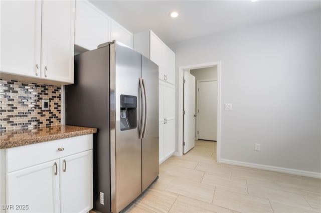 kitchen featuring backsplash, white cabinetry, and stainless steel fridge with ice dispenser