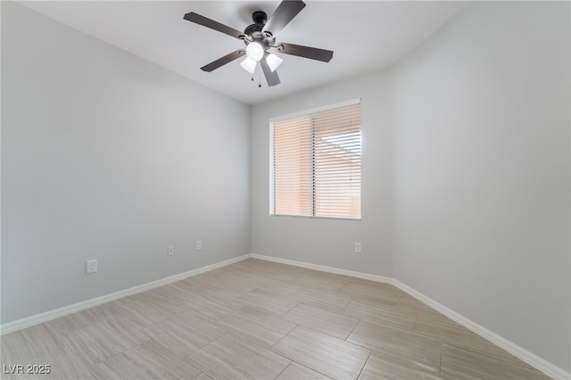 unfurnished room featuring ceiling fan and baseboards