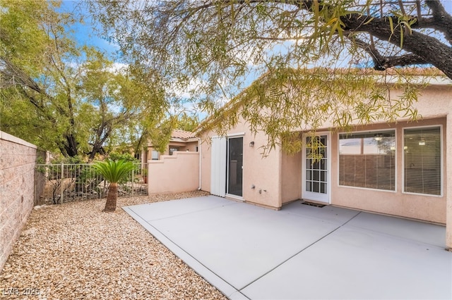 back of house with a patio area, fence, and stucco siding