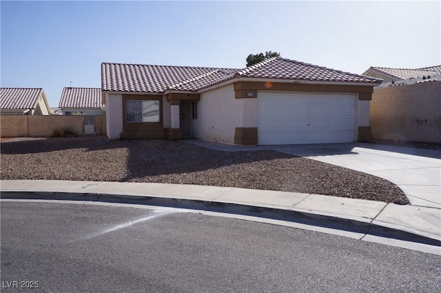 view of front facade with an attached garage, fence, a tile roof, driveway, and stucco siding