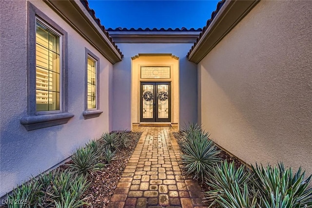 property entrance with french doors and stucco siding