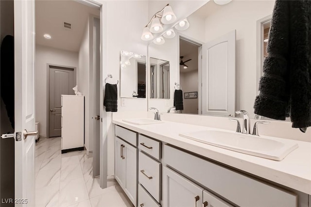 full bathroom with marble finish floor, double vanity, a sink, and visible vents