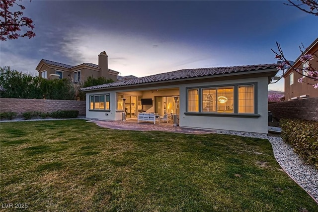 back of property with a patio, a tile roof, fence, a yard, and stucco siding