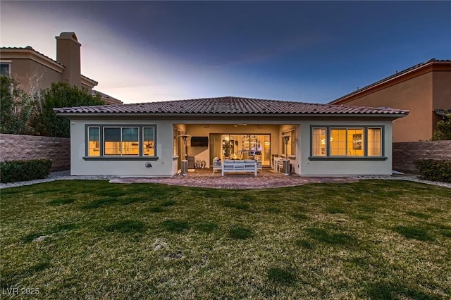 rear view of house featuring a patio area, a lawn, an outdoor living space, and stucco siding