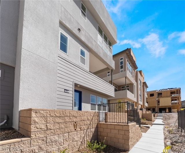 view of building exterior with a residential view and fence