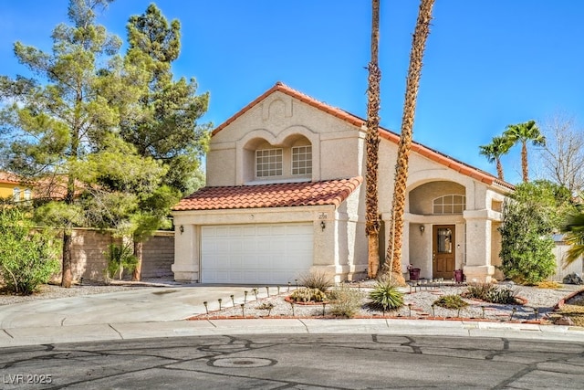 mediterranean / spanish house with a garage, concrete driveway, a tiled roof, fence, and stucco siding