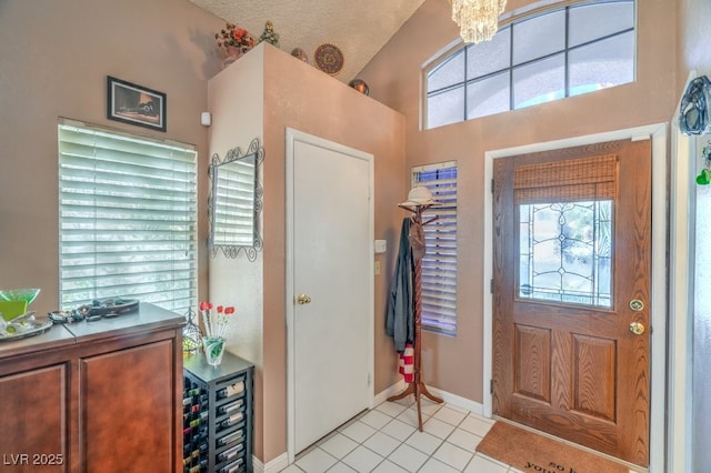 entrance foyer with a healthy amount of sunlight, beverage cooler, a notable chandelier, and light tile patterned flooring