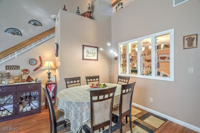 dining space with visible vents, baseboards, and wood finished floors