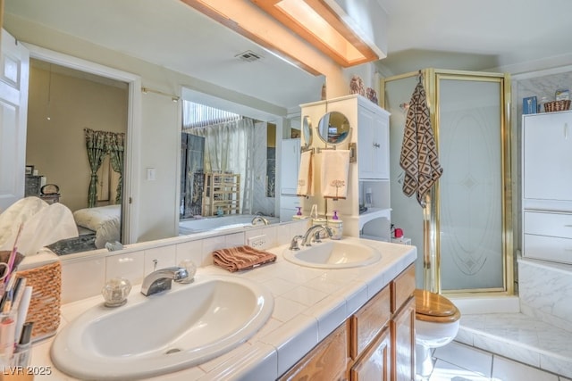 ensuite bathroom with a stall shower, visible vents, and a sink