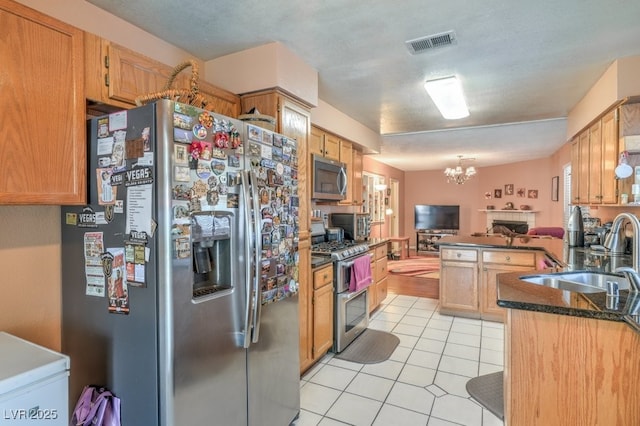 kitchen featuring light tile patterned floors, visible vents, appliances with stainless steel finishes, a chandelier, and a sink