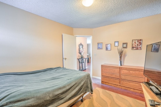 bedroom with baseboards and a textured ceiling