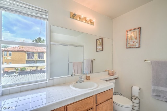 full bath with a stall shower, vanity, and toilet