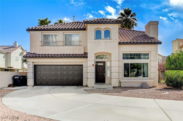 mediterranean / spanish house with stucco siding, an attached garage, driveway, and fence