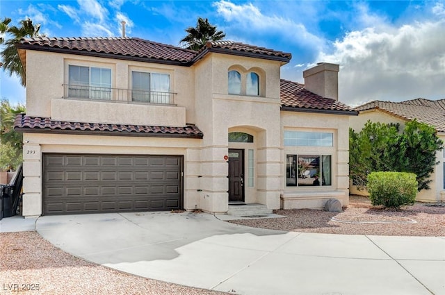 mediterranean / spanish house with a balcony, an attached garage, a chimney, stucco siding, and concrete driveway