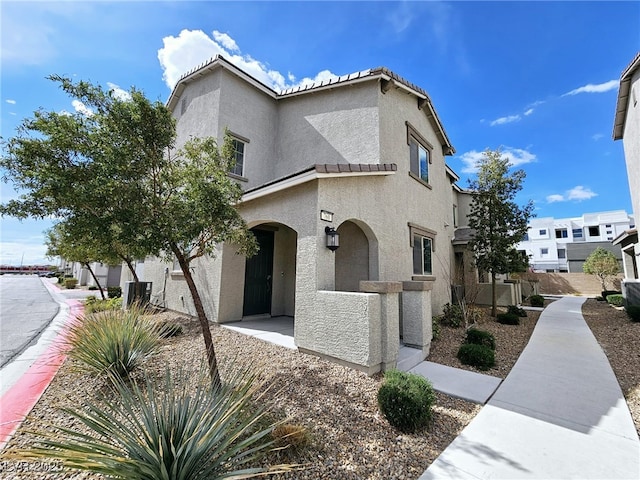 view of side of property with a tile roof and stucco siding