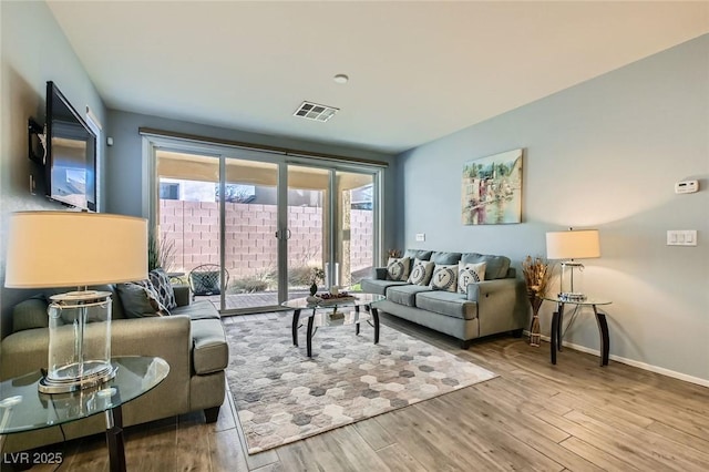 living room with french doors, baseboards, visible vents, and wood finished floors