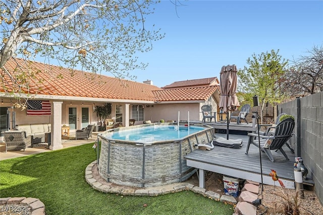 view of swimming pool featuring a fenced in pool, a lawn, an outdoor hangout area, fence, and a deck