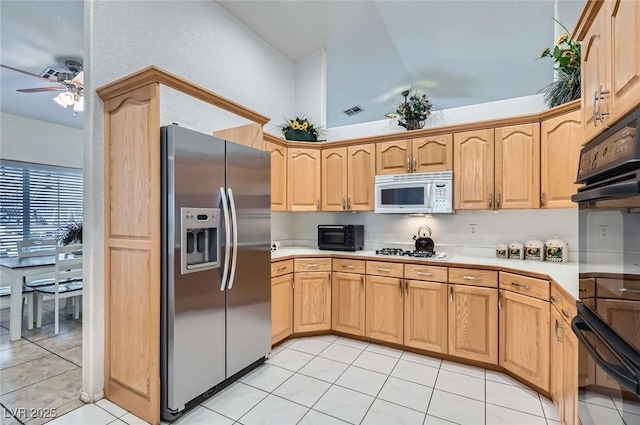 kitchen with white appliances, light tile patterned floors, a ceiling fan, light countertops, and light brown cabinets