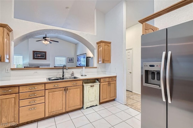 kitchen featuring a ceiling fan, light countertops, stainless steel fridge, and a sink