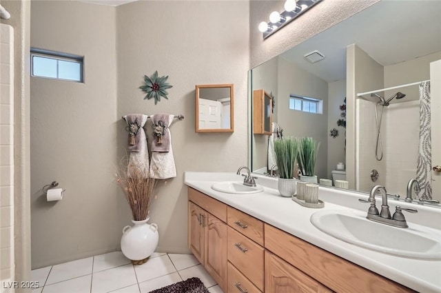 full bathroom featuring toilet, a wealth of natural light, tile patterned flooring, and a sink