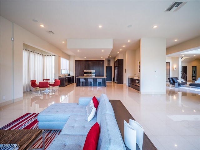 living area with recessed lighting, visible vents, baseboards, and light tile patterned floors