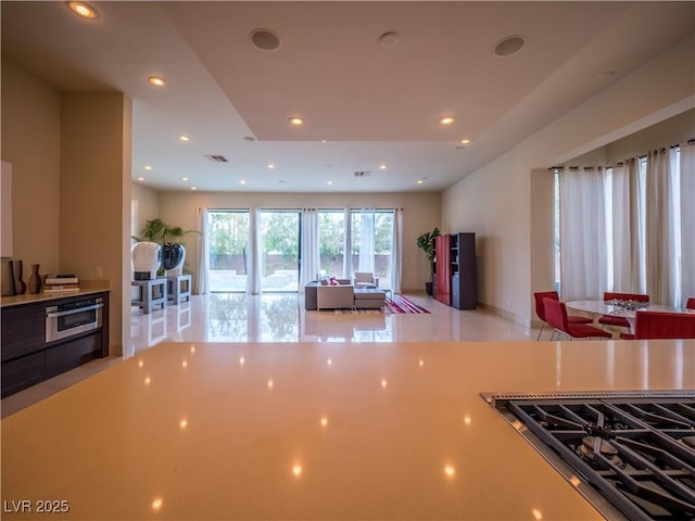 kitchen featuring recessed lighting, light countertops, visible vents, stovetop with downdraft, and open floor plan