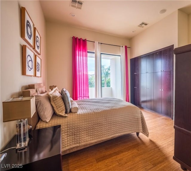 bedroom with visible vents and wood finished floors