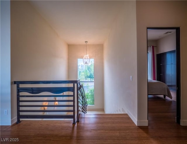 stairway with visible vents, baseboards, a chandelier, and wood finished floors