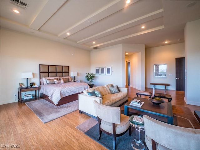 bedroom with beam ceiling, recessed lighting, visible vents, wood finished floors, and baseboards